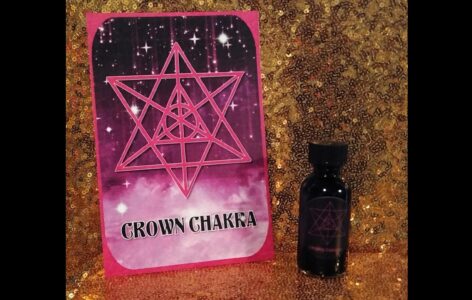 A bottle of crown chakra oil sitting next to a card.