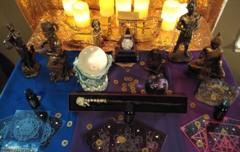 A table with candles and various figurines on it.